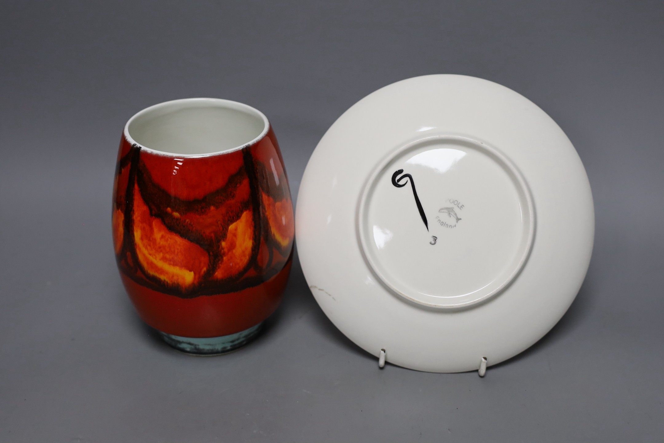 A Poole pottery orange and red abstract vase and plate, 20cm diameter